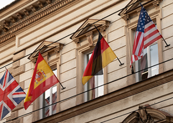 Flags of spain, germany, USA and the UK on the side of a building